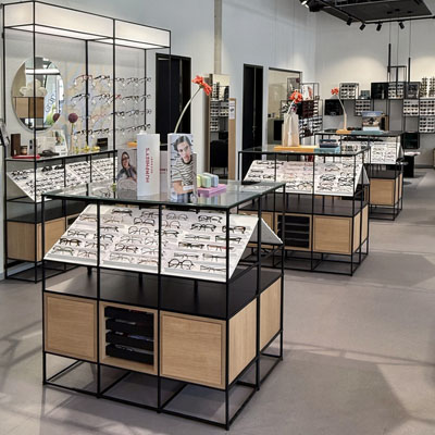 Modular mid-room furniture with eyewear displays, storage and integrated presentation areas.