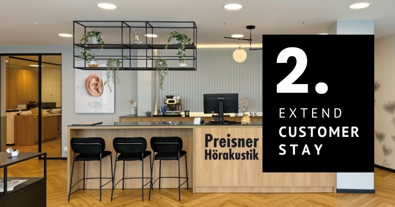 Modern hearing care reception with seating and plants designed to extend customer dwell time.